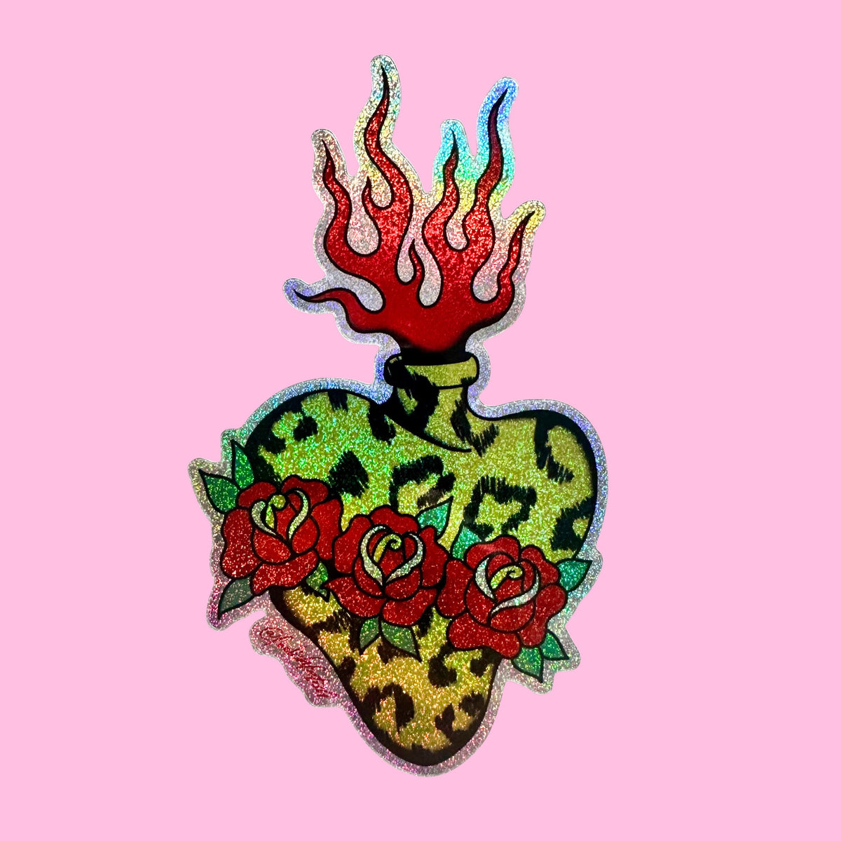 A decorative heart-shaped patch with a leopard print pattern, red roses, and red flames on top, shown on a solid pink background.