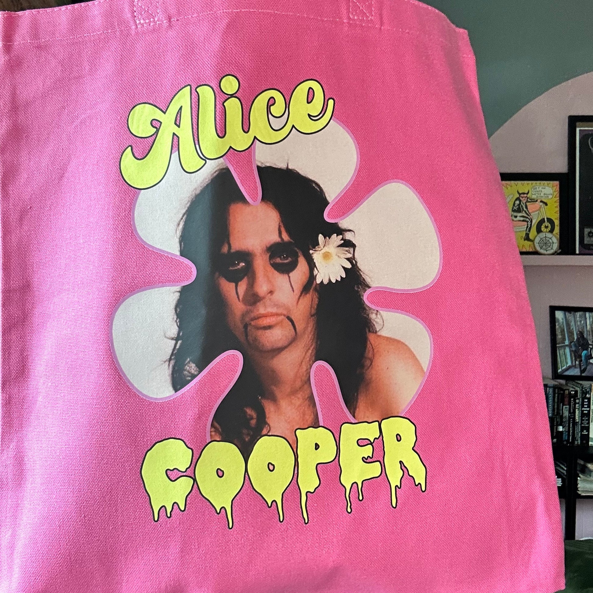 Pink tote bag with a graphic of a person and the text 'Alice Cooper' on a blurred background.