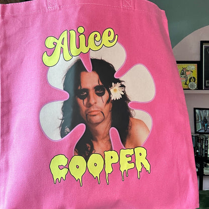 Pink tote bag with a graphic of a person and the text 'Alice Cooper' on a blurred background.