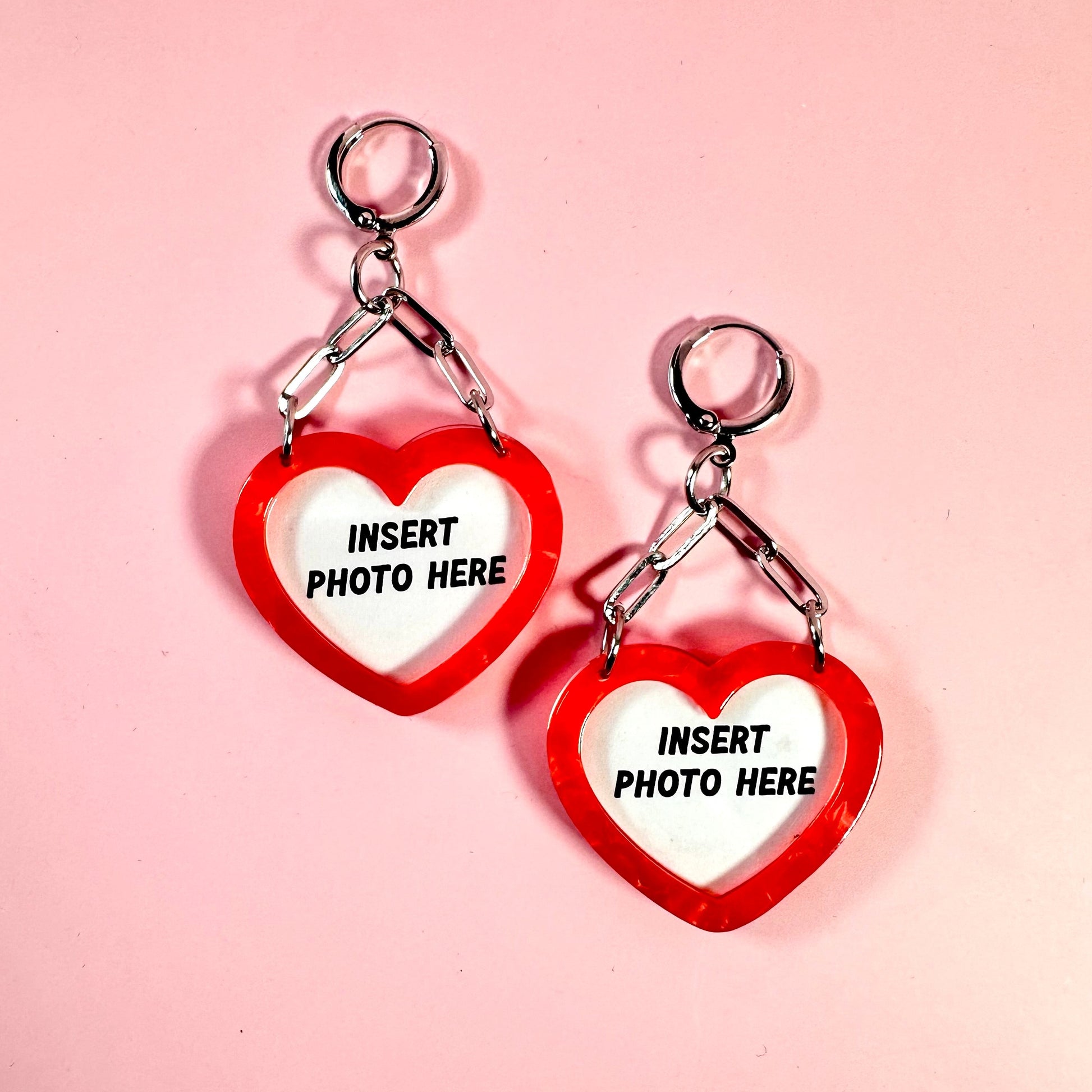 Heart-shaped keychains with 'Insert photo here' text on a pink background