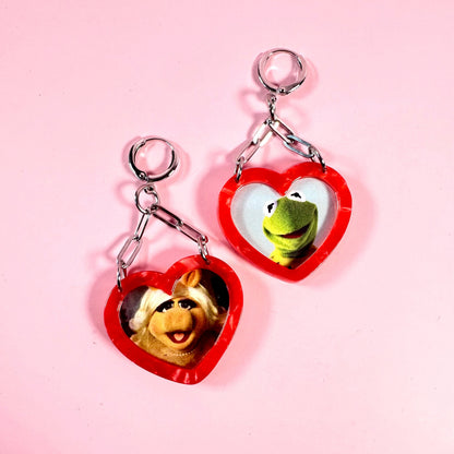 Heart-shaped keychains with Muppets characters on a pink background
