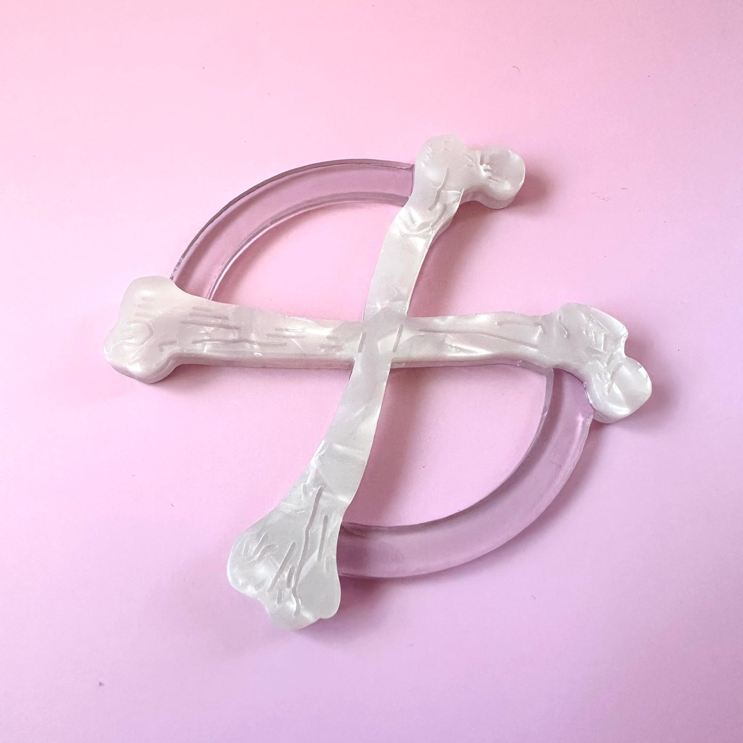 white crossbones circle scarf ring on pink background