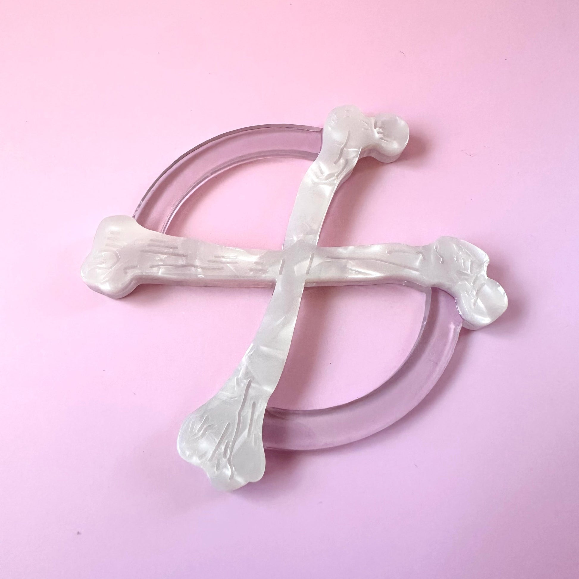 white crossbones circle scarf ring on pink background