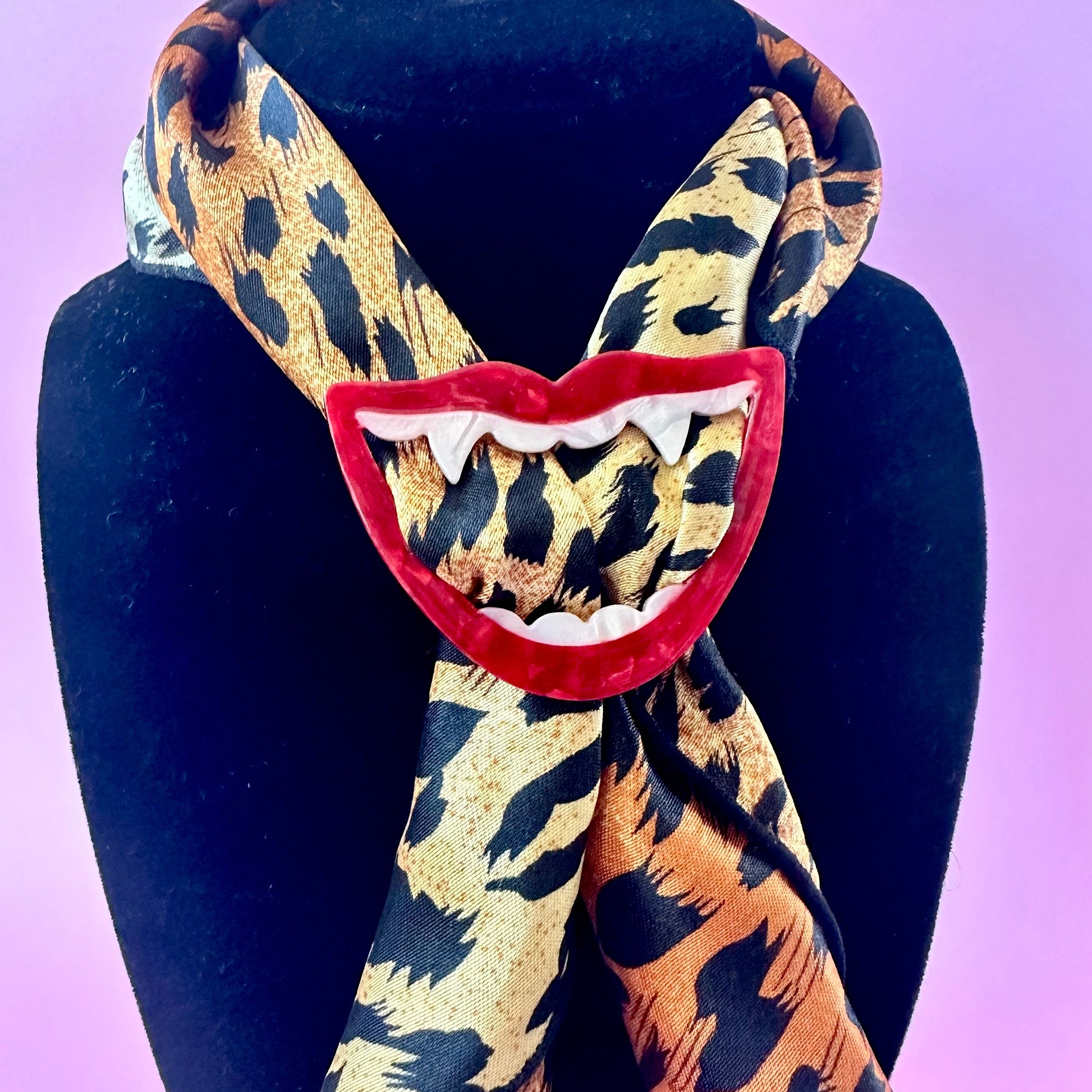 scarf ring of a red open mouth with white fangs on a leopard print scarf