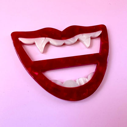 red mouth with fang scarf ring on pink background
